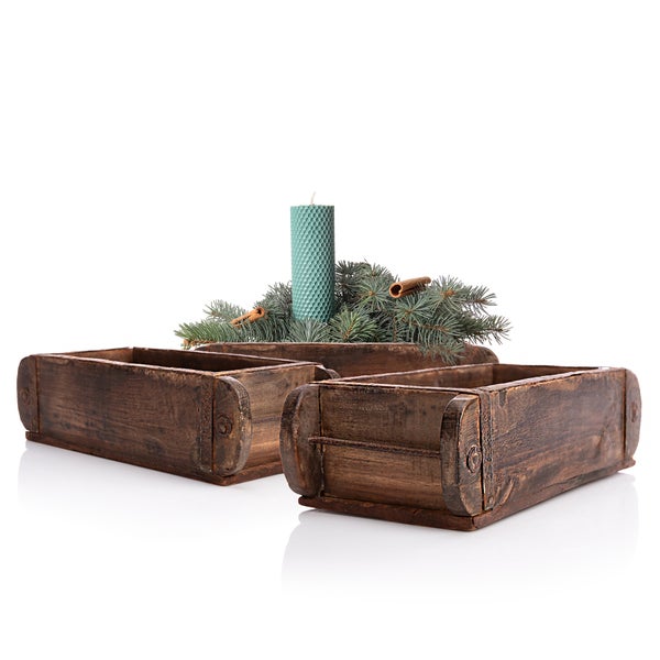 Dekoration mit Holzkisten, einer Kerze und Tannenzweigen