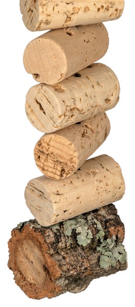 Stapel aus fünf Weinkorken aus Naturkork auf einem Stück Korkrinde.