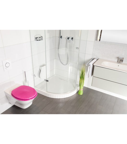 Modernes helles Badezimmer mit wandhängendem WC, pinkfarbenem Deckel, Glasdusche, weißem Waschtisch und dunklem Boden in Holzoptik.