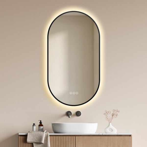 Ovaler Badezimmerspiegel mit LED Beleuchtung und Touch Steuerung über einem Waschtisch mit Waschbecken und Holzunterschrank.