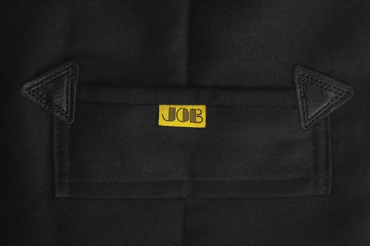 Detailansicht einer Tasche an einem schwarzen Kleidungsstück mit Lederverstärkungen und JCB Logo.