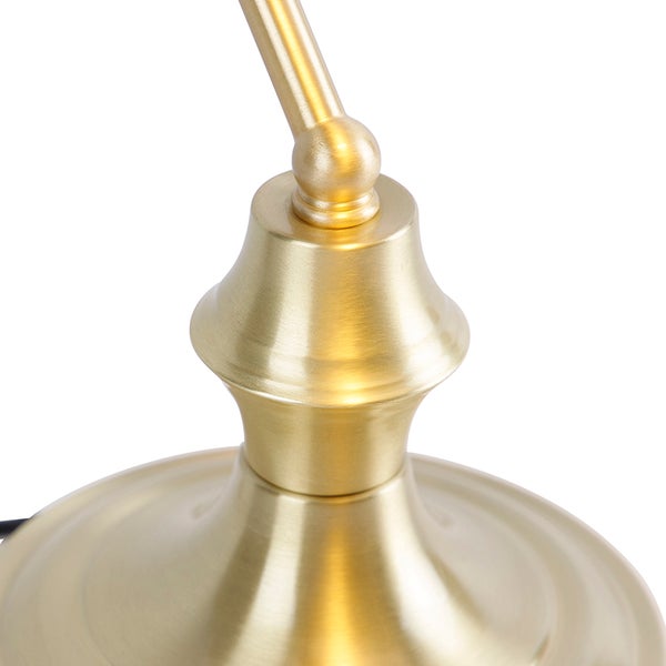 Detailaufnahme einer goldenen Lampe mit verstellbarem Arm