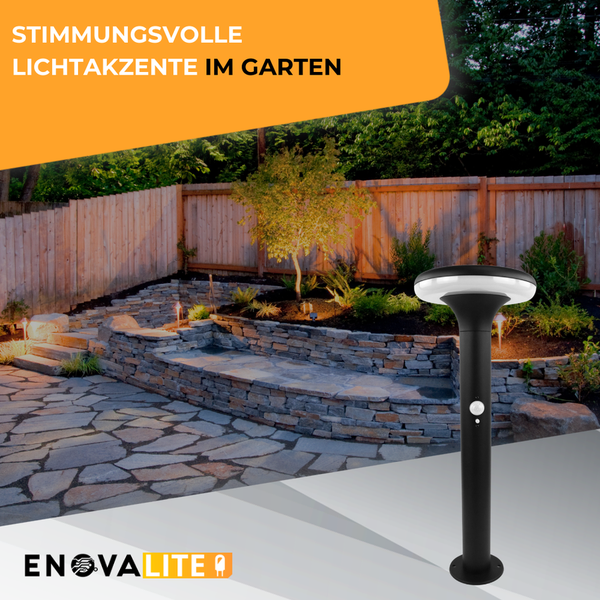 Gartenszene mit Steinweg, Steinmauer, Zaun und einer schwarzen EnovaLite Wegeleuchte