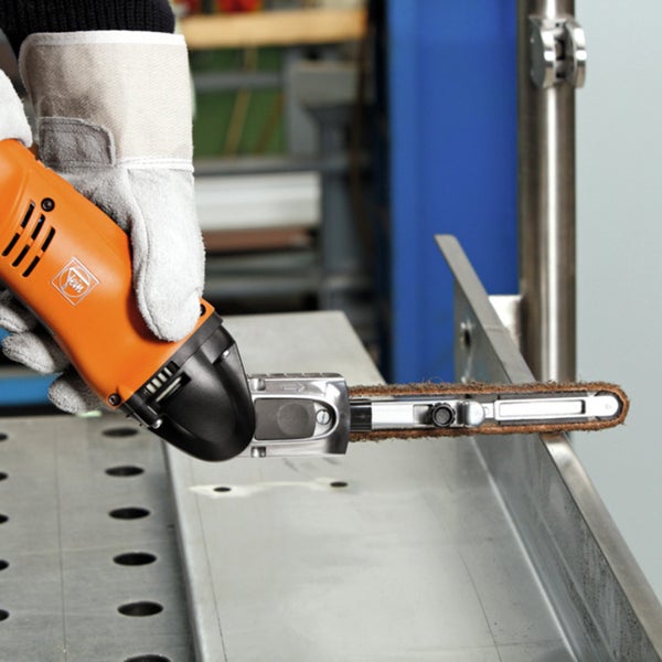 Handgeführte Fein Bandfeile bei der Metallbearbeitung an einem Werkstück in einer Werkstatt.