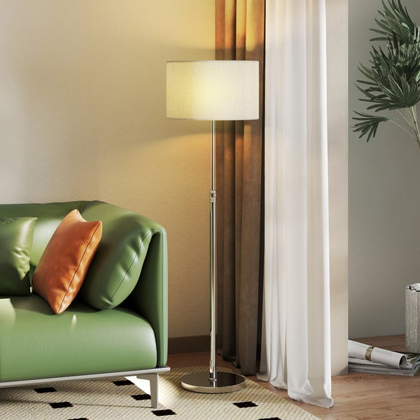 Moderne Stehleuchte mit zylindrischem Lampenschirm neben einem Sofa im Wohnzimmer