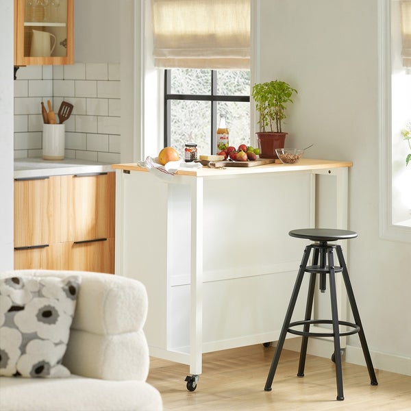 Küchenszene mit mobilem Küchentisch, Barhocker, Obst und Küchenutensilien.