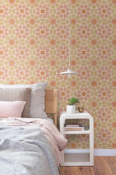 Vliestapete mit geometrischem Sternenmuster in einem hellen Schlafzimmer mit Holzbett, Nachttisch und Hängelampe.