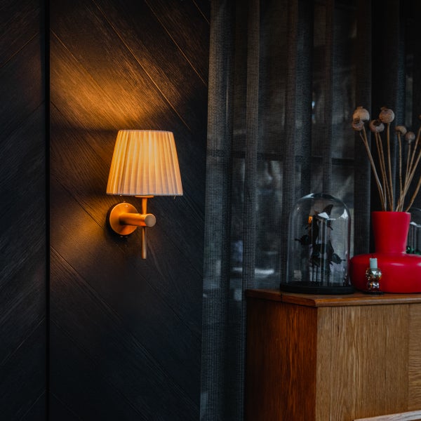 Wandleuchte mit Lampenschirm, Dekoration mit Glasglocke und Blumenvase auf Kommode