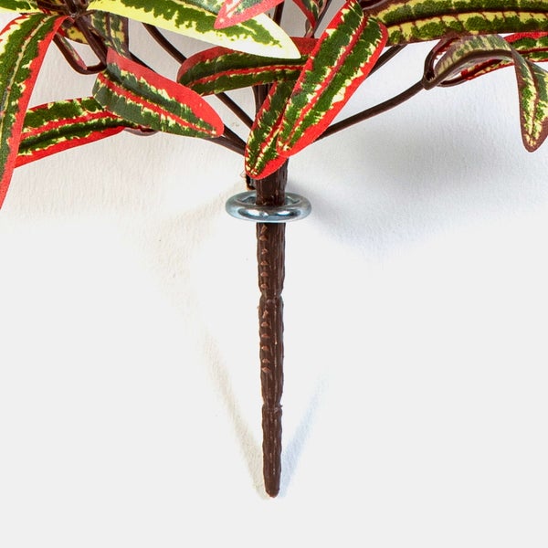 Künstlicher Croton Zweig mit bunten Blättern und strukturiertem braunem Stiel.