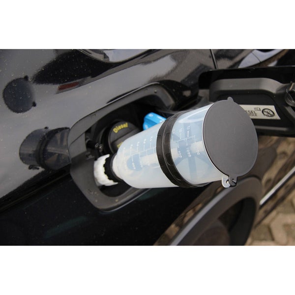 Nachfüllflasche für AdBlue wird in den Einfüllstutzen eines Autos eingesetzt.