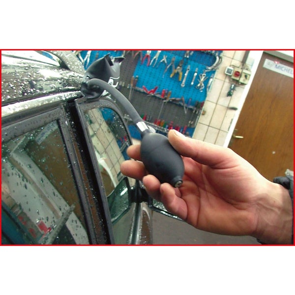 Hand die ein Airbag-Öffnungswerkzeug an einer Autotür verwendet.