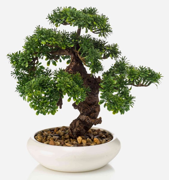 Künstlicher Bonsai Baum mit strukturiertem Stamm und grünen Blättern in einer weißen Schale mit Zierkies.