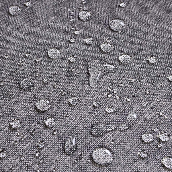 Wassertropfen auf grauem, wasserabweisendem Webstoff.