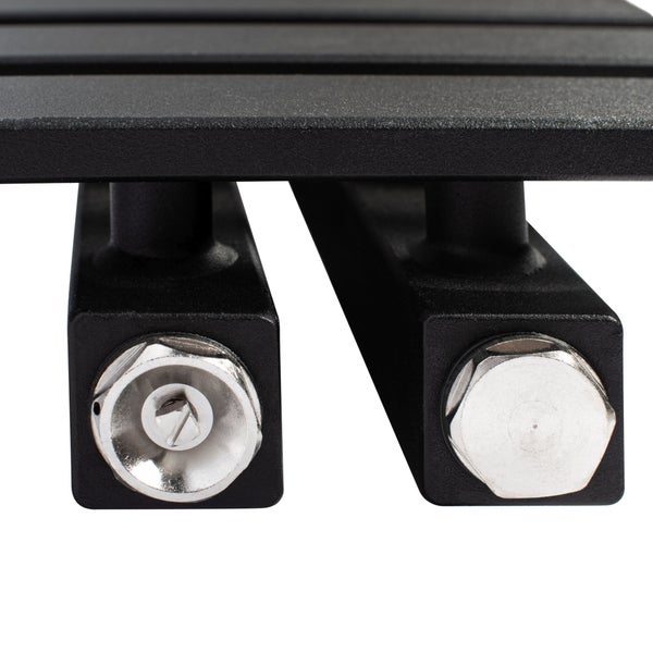 Nahaufnahme der Anschlüsse eines schwarzen Heizkörpers mit silbernem Entlüftungsventil und Blindstopfen.