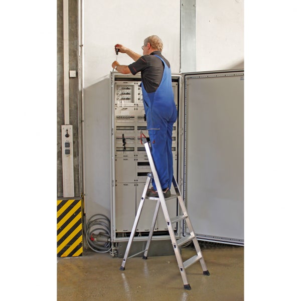 Elektriker arbeitet auf einer Stufenleiter an einem Schaltschrank
