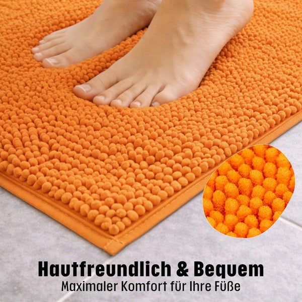 Weiche Badematte aus Chenille mit strukturierter Oberfläche, zwei nackte Füße auf der Matte, Detailansicht der Fasern.