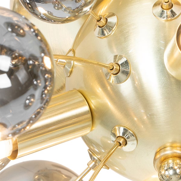 Detailaufnahme einer modernen Lampe mit goldenen Elementen und Glaskugeln