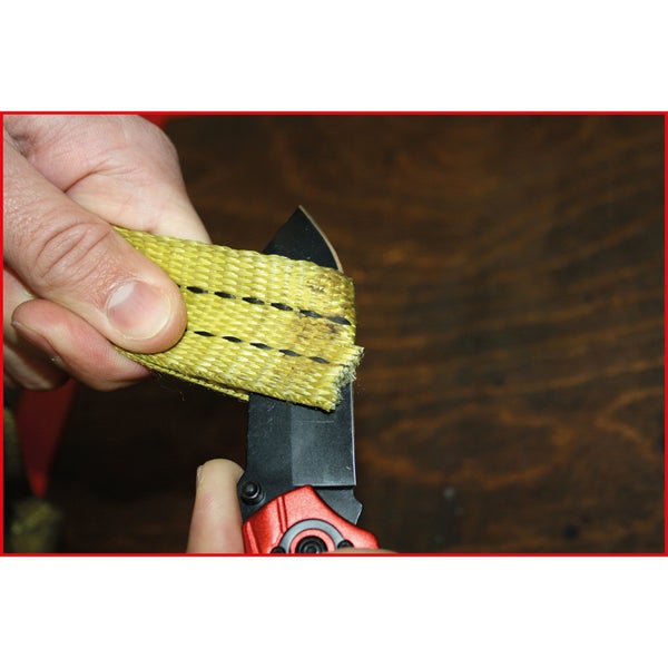 Ein gelbes Textilband wird mit einem schwarzen Messer geschnitten.