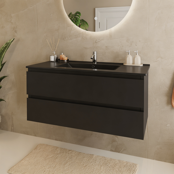 Moderner, wandhängender Badunterschrank in Schwarz mit integriertem Waschbecken und zwei Schubladen in einem hellen Badezimmer.
