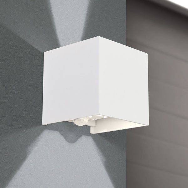 Würfelförmige LED-Außenwandleuchte in Weiß mit Bewegungsmelder, Up-and-Down-Lichteffekt an einer grauen Hauswand.