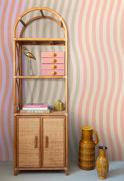 Szene mit einem Bambusregal, Dekoration und einer gemusterten Tapete
