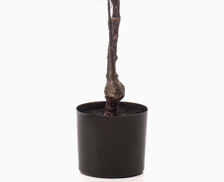 Künstlicher Baum mit grünen Blättern im schwarzen Topf.