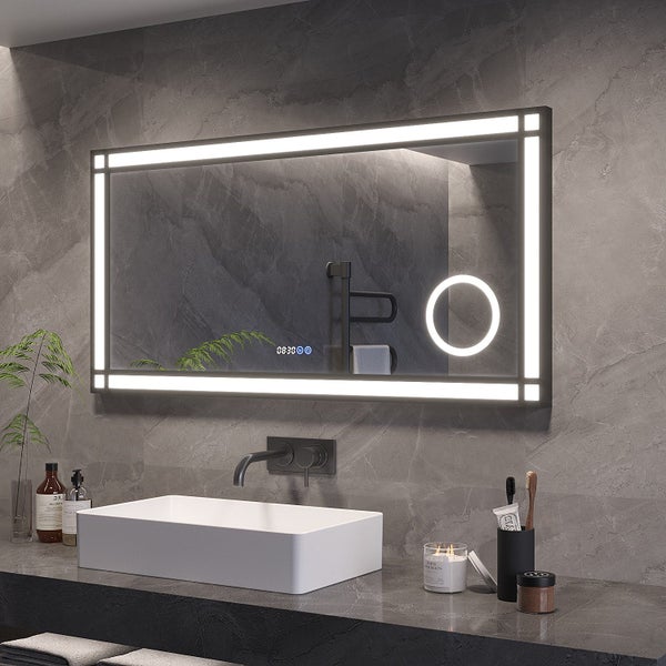 Rechteckiger Badezimmerspiegel mit integrierter LED Beleuchtung, Uhranzeige und Kosmetikspiegel Funktion an einer Wand über einem Waschbecken.