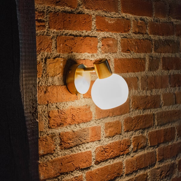 Wandleuchte mit Kugelglas an Ziegelwand