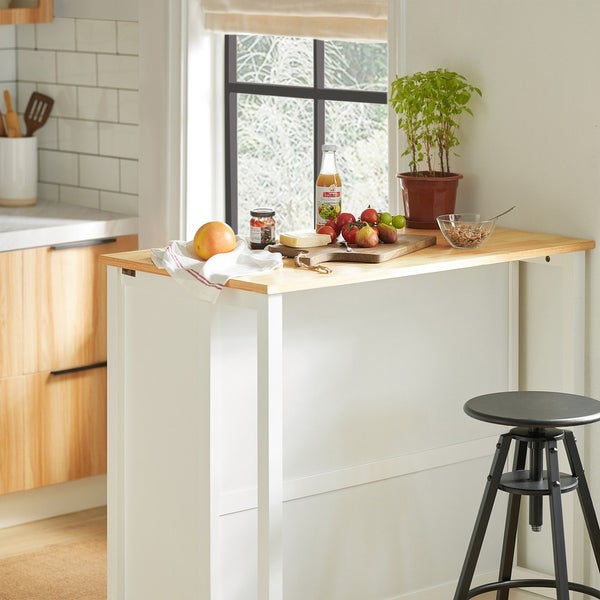 Küchenszene mit einer weissen Bartheke mit einer Holzplatte und einem Barhocker.