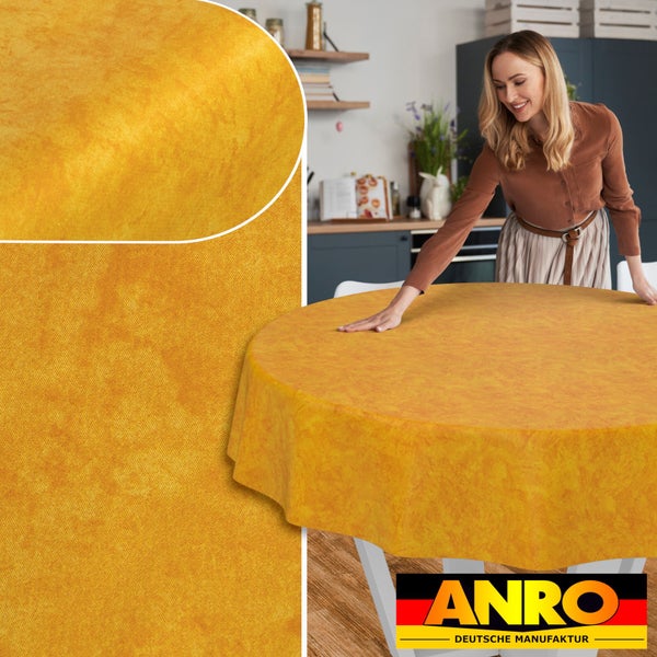 Runde, marmorierte Tischdecke in einer modernen Küche, von einer Frau auf einem Tisch ausgebreitet, mit Detailansicht und ANRO Deutsche Manufaktur Logo.