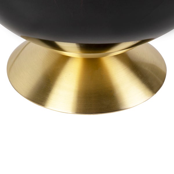 Detail einer Lampe mit schwarzem Lampenschirm und goldfarbenem Sockel