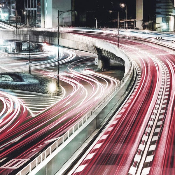 Langzeitbelichtung einer nächtlichen Stadtautobahn mit Lichtspuren