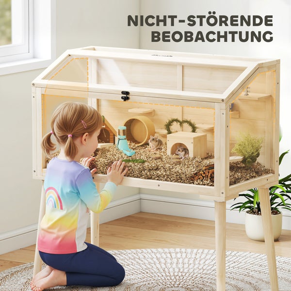 Hölzernes Kleintiergehege auf Stelzen mit großem Sichtfenster, inklusive Zubehör und Hamstern, beobachtet von einem Kind.