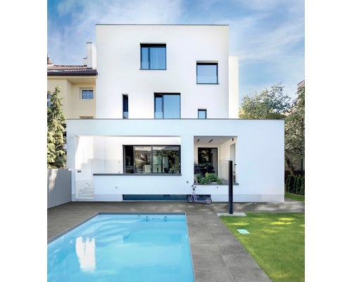 Modernes Haus mit Pool und grauem Fliesenboden im Außenbereich.