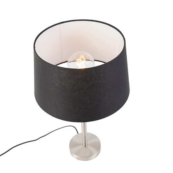 Moderne Tischleuchte mit schwarzem Stoffschirm und rundem Metallfuß inklusive eingeschalteter Glühbirne