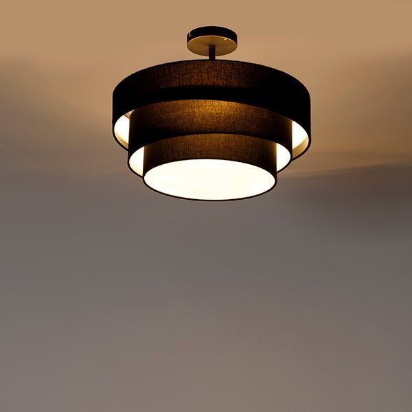Dreistufige Deckenleuchte mit schwarzen Stoffschirmen, die warmes Licht abgeben.