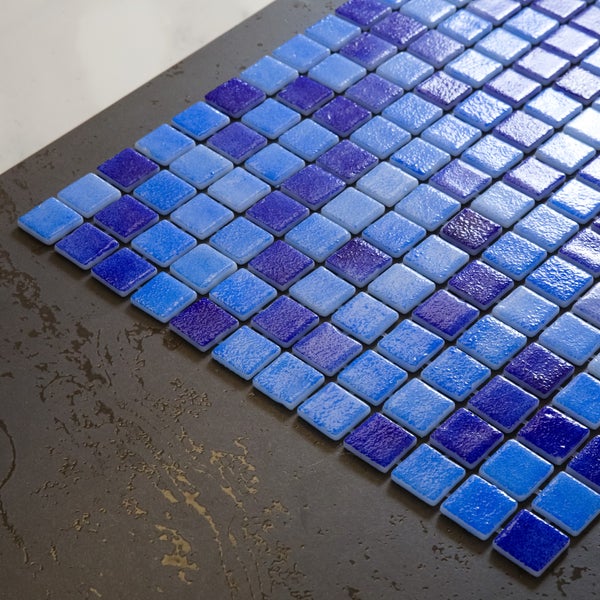 Glasmosaikfliesen in verschiedenen Blau- und Violetttönen mit strukturierter Oberfläche.