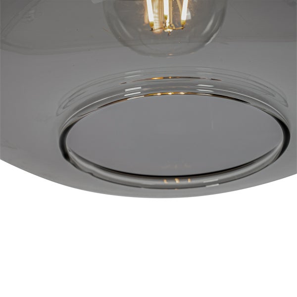 Nahaufnahme eines runden Lampenschirms aus Glas in Rauchgrau mit sichtbarem Filament-Leuchtmittel.