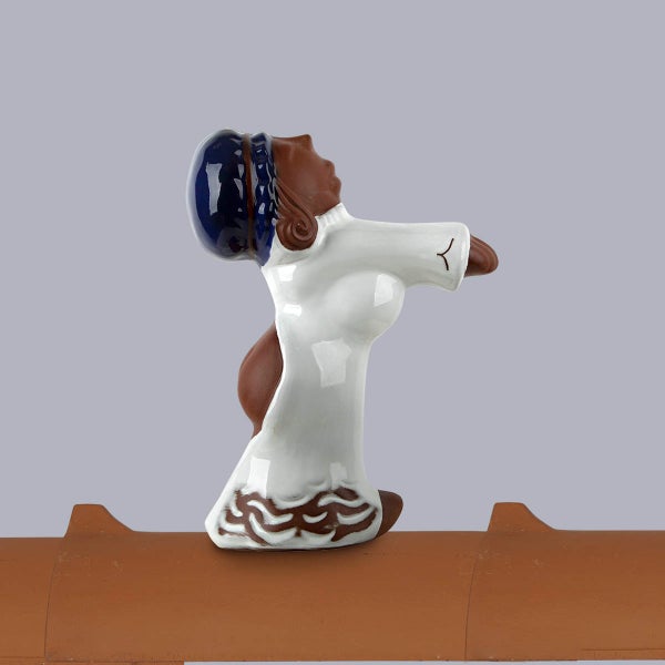 Dachschmuck aus Keramik, Firstfigur Frau auf einem braunen Firstziegel.