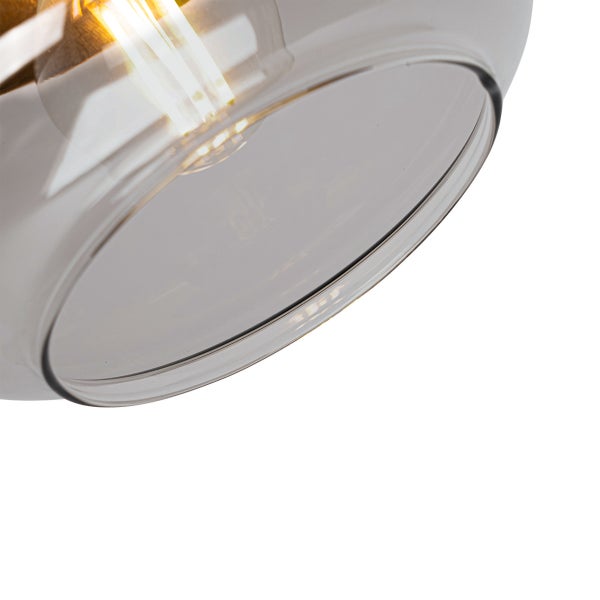 Nahaufnahme eines Lampenschirms aus Glas mit einem leuchtenden LED-Filament-Leuchtmittel.
