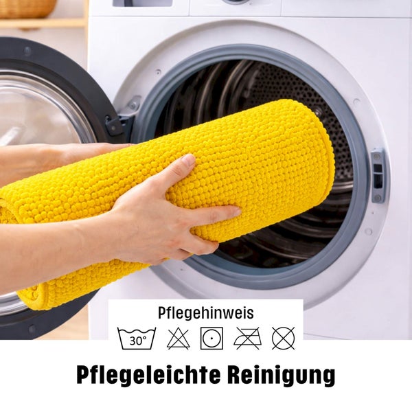 Gelbe Badmatte wird in eine Waschmaschine gelegt, waschbar bei 30 Grad, pflegeleichte Reinigung.