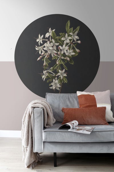 Dekoratives Wandpaneel mit Blumenmuster über einem grauen Sofa