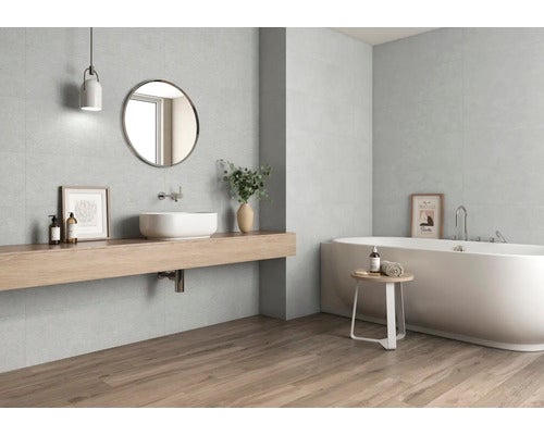 Modernes Badezimmer mit Badewanne, Waschtisch und grauen Wandfliesen.