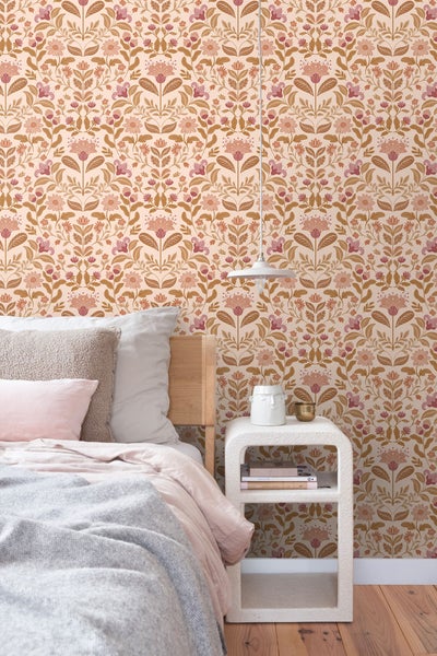 Schlafzimmer mit Bett, Nachttisch und floraler Tapete