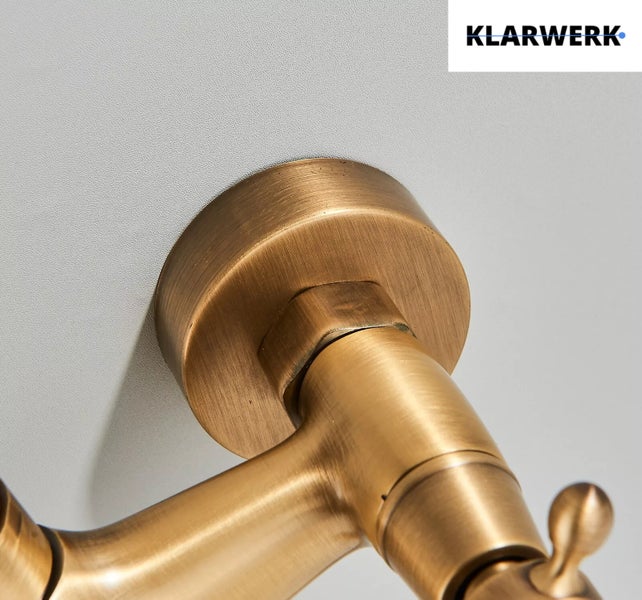 Wandbefestigung einer Armatur in Messingoptik mit Klarwerk Logo