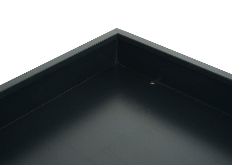 Detailansicht der Ecke eines dunklen Pflanzkastens oder Tabletts aus Metall.