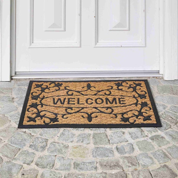 Fußmatte mit Willkommensgruß vor einer Tür