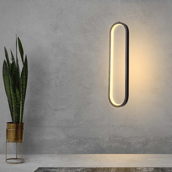 Dekorative LED-Hängeleuchte mit länglichem Design neben einer Zimmerpflanze in einem Topf