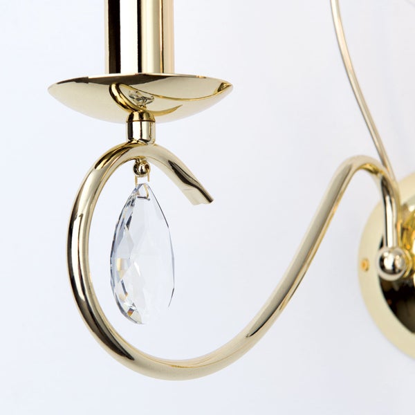 Wandleuchte aus Metall mit goldfarbener Oberfläche und einem tropfenförmigen Kristallanhänger