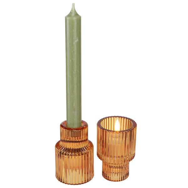 Bernsteinfarbener, geriffelter Kerzenhalter aus Glas mit grüner Stabkerze und brennendem Teelicht.